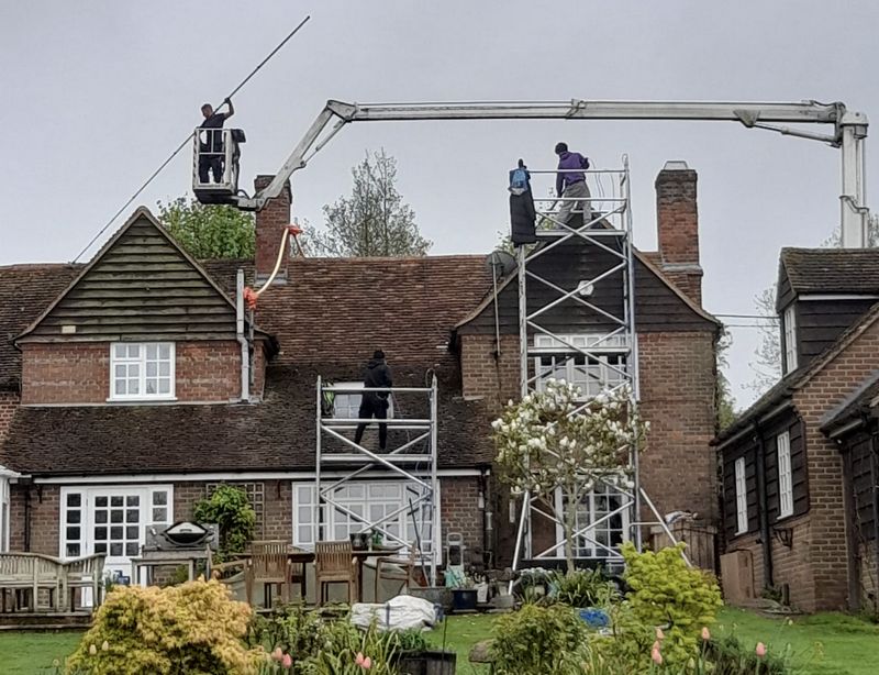 The Moss Cleaners using cherry picker and scaffolding to clean roof safely and professionally in Warwick, Warwickshire